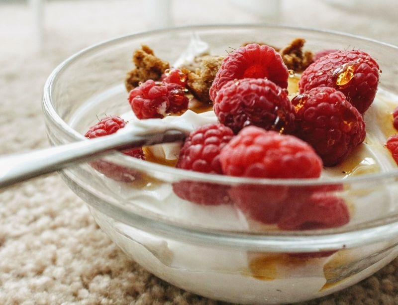 Bowl of rasberry yogurt with honey